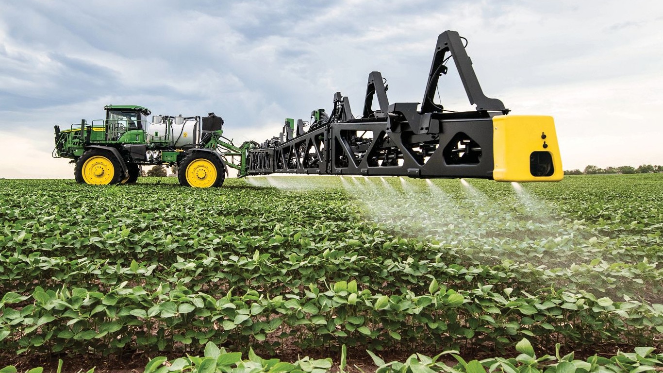 Közeli felvétel a John Deere permetezőgép szórókeretéről nyílt terepen.