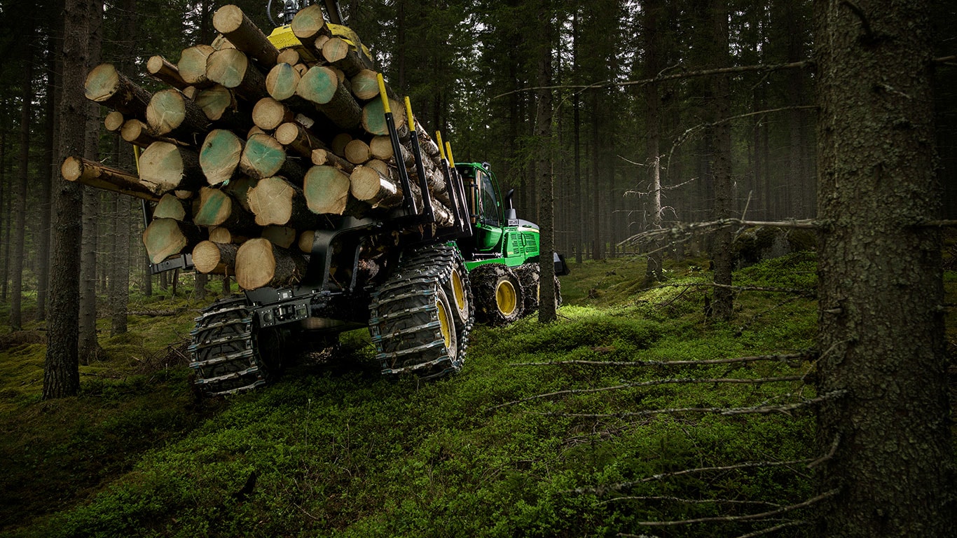 A John Deere 1510G fakihordó rönköket szállít az erdőben