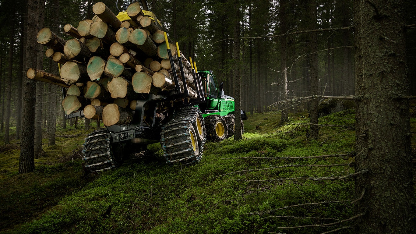 A John Deere 1510G fakihordó rönköket szállít az erdőben