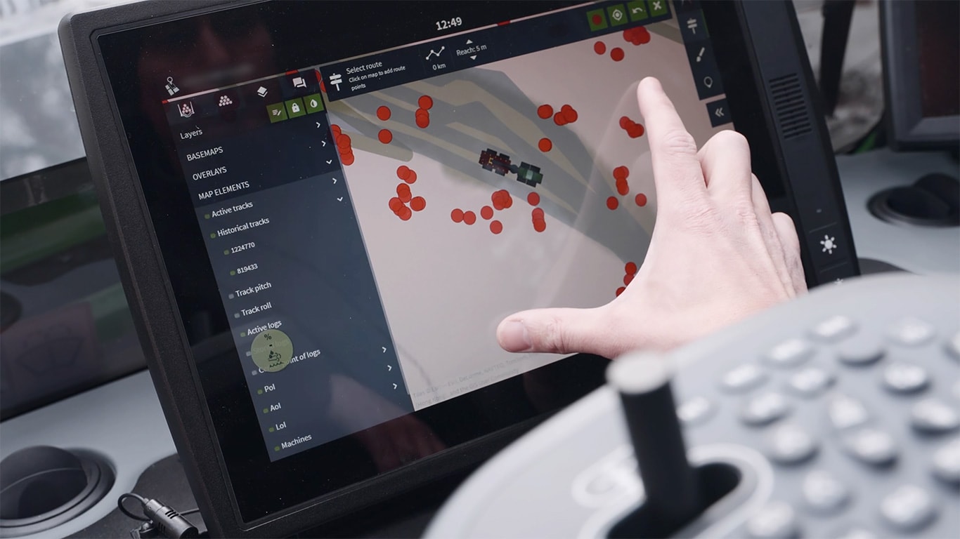 John Deere TimberMatic Maps képernyő és egy kéz