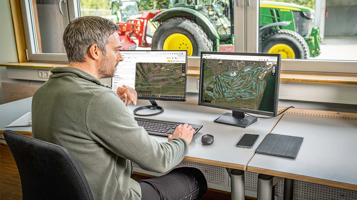 A golfpálya térképét a vezető golfpálya-karbantartó szemléli a számítógépén.