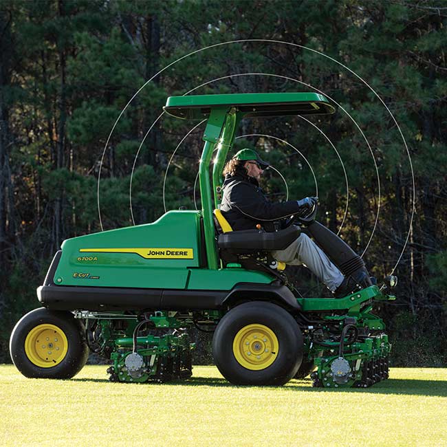 Golfpálya-karbantartó dolgozik a pályán John Deere golfpálya-fűnyíróval, internetkapcsolaton alapuló technológiát használva.
