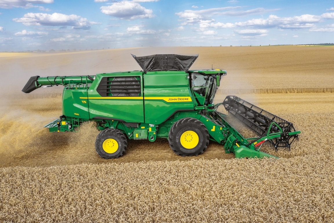 A John Deere kombájn oldalnézete az adapterrel, amely búzát takarít be nagy mezőgazdasági területen
