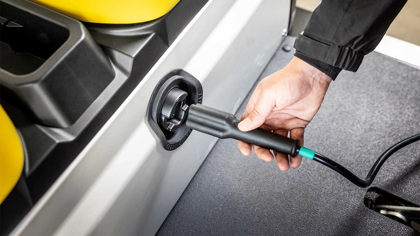 A töltőkábelt kézi csatlakoztatása a John Deere Gator GS elektromos haszonjármű oldalsó csatlakozójához.