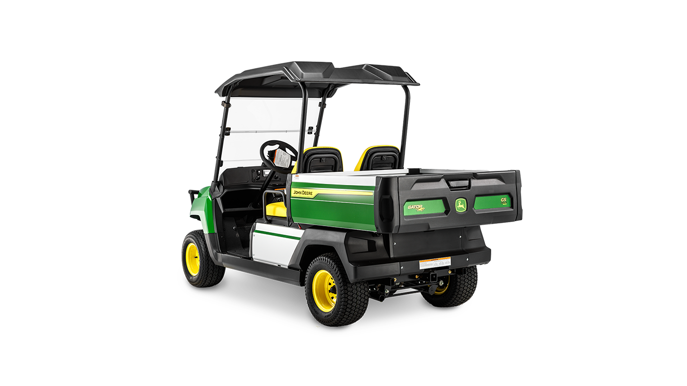 A John Deere Gator GS elektromos modelljének hátulnézete szögből, amely a rakfelületet és a fekete tető alatti dupla ülést mutatja.