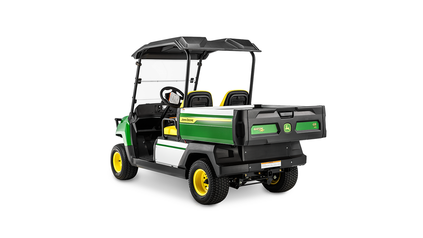 A John Deere Gator GS benzinmotoros modell hátulnézete szögből, amely a rakfelületet, a dupla ülést és a védőtetőt mutatja.