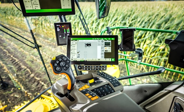 F9 700 önjáró szecskázógép, amely egy John Deere 6R traktor által húzott Joskin pótkocsiba ürít