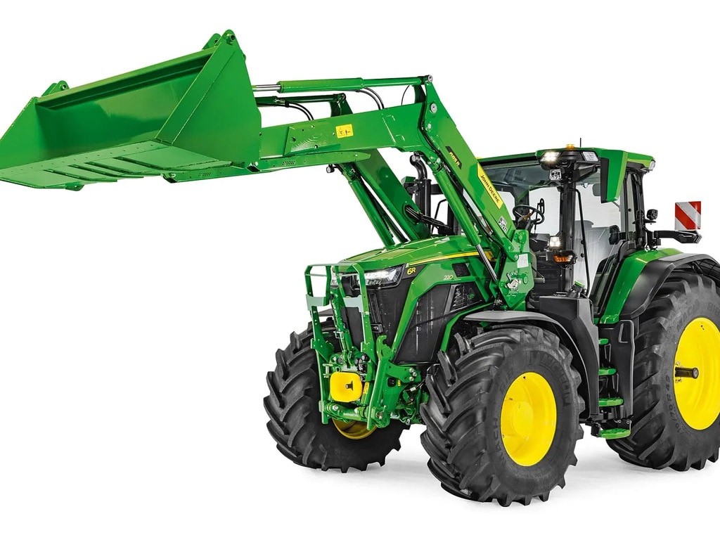 John Deere traktor leengedett homlokrakodóval és felkapcsolt kanállal, elszigetelve a fehér háttéren.