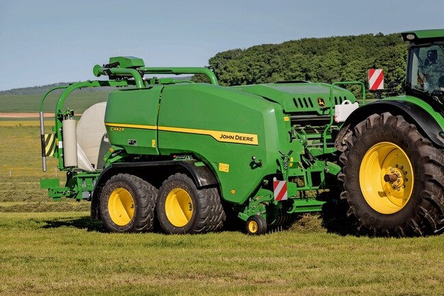 Egy John Deere C442R csomagoló bálázó nagy tömörségű silótakarmány bálát készít